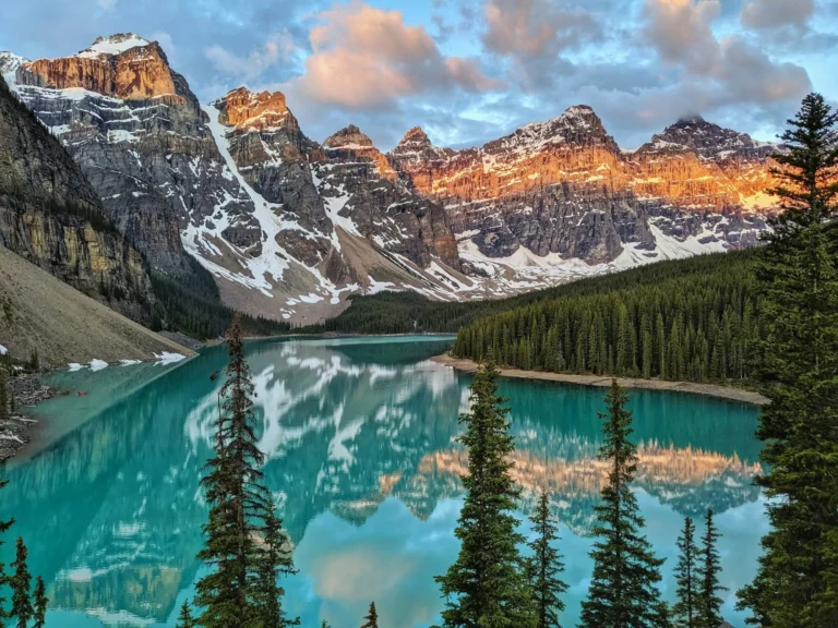 Golden morning light on mountain peaks above a glacial lake